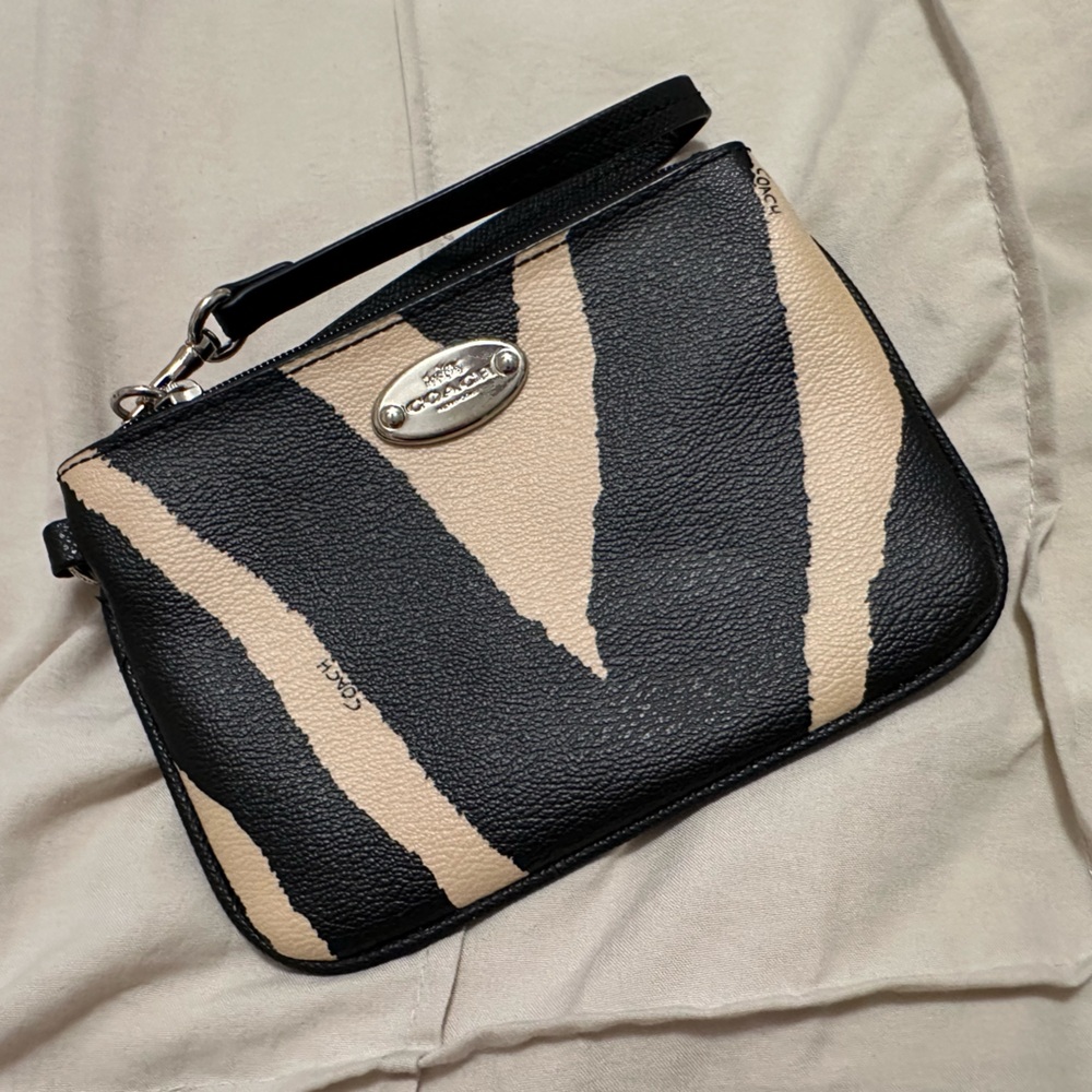 Coach wristlet. Black and tan zebra striped. Silver hardware.